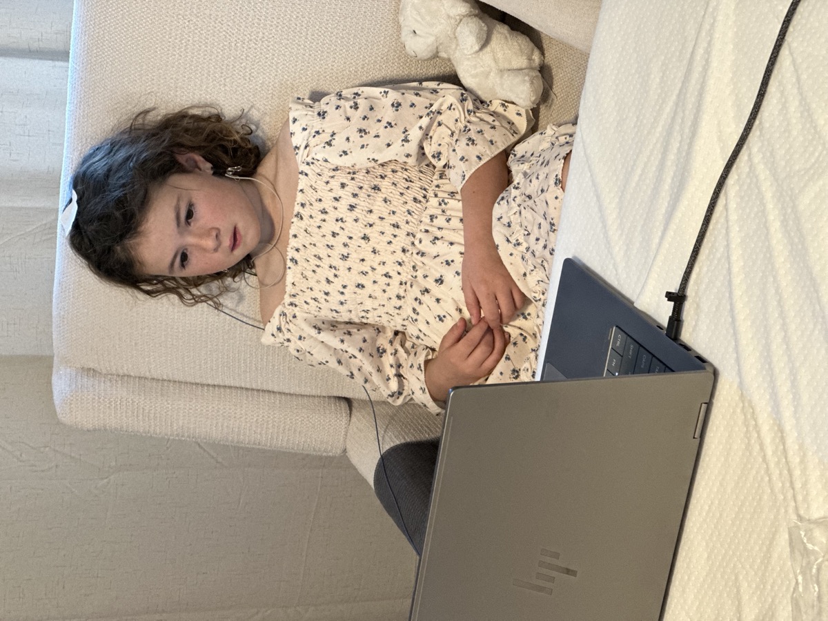 Child doing neurofeedback home training session with laptop